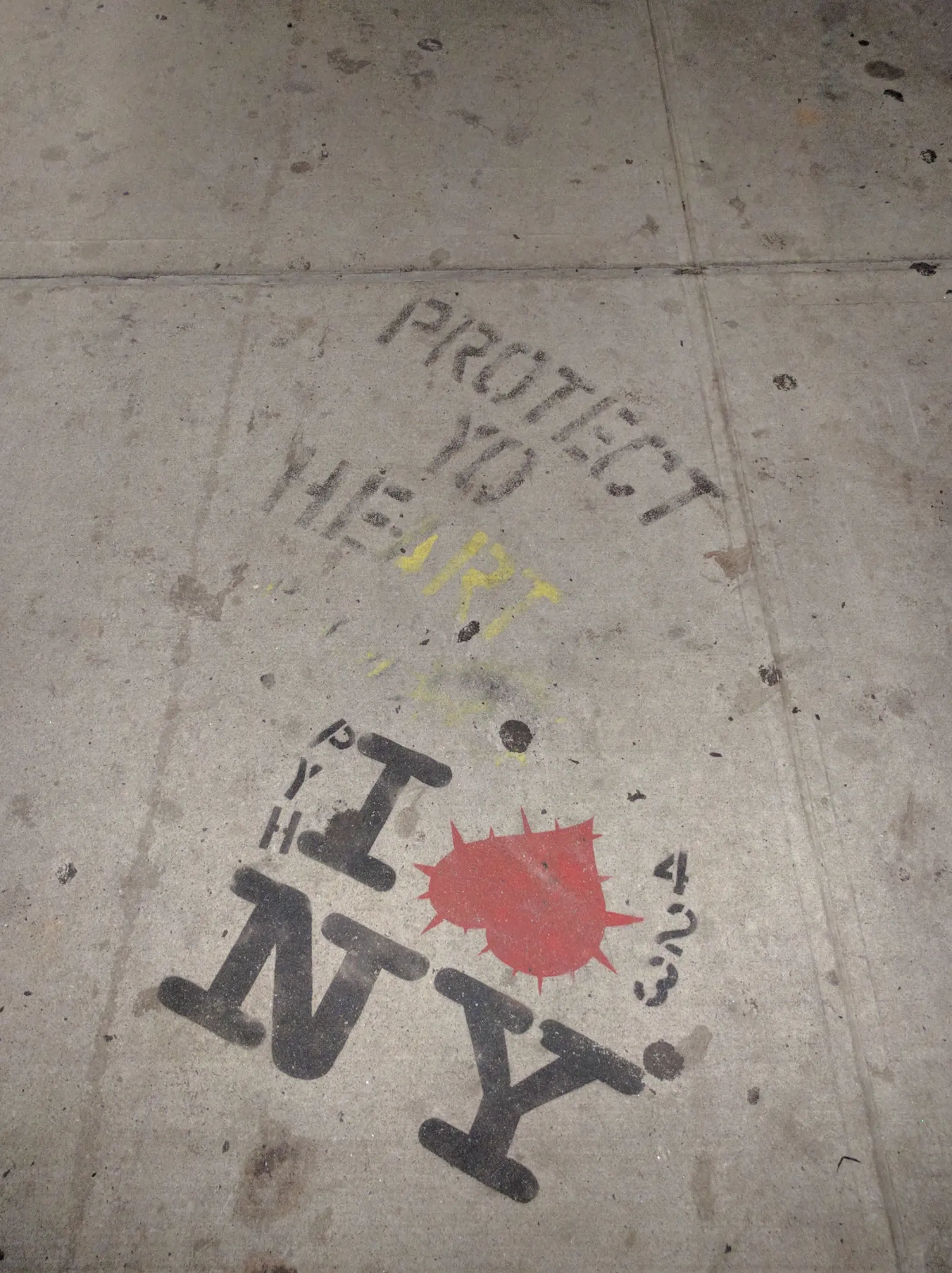A sidewalk stencil reading Protect Yo Heart above an I Love NY graphic